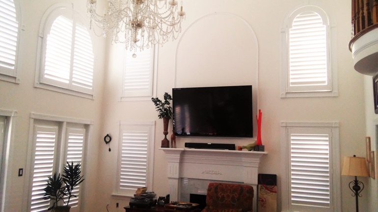 Fort Myers great room with mounted TV and high-ceiling windows.